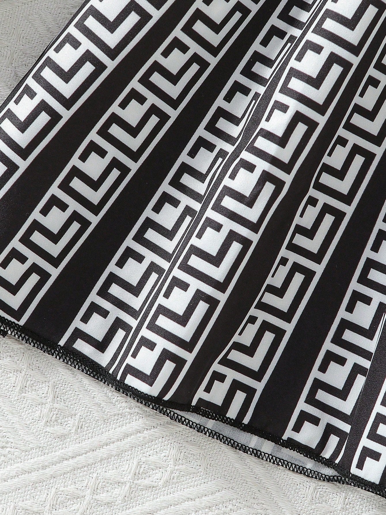 Prenda blanco y negro vestido para bebe detalle de falda plisada y estampado geométrico