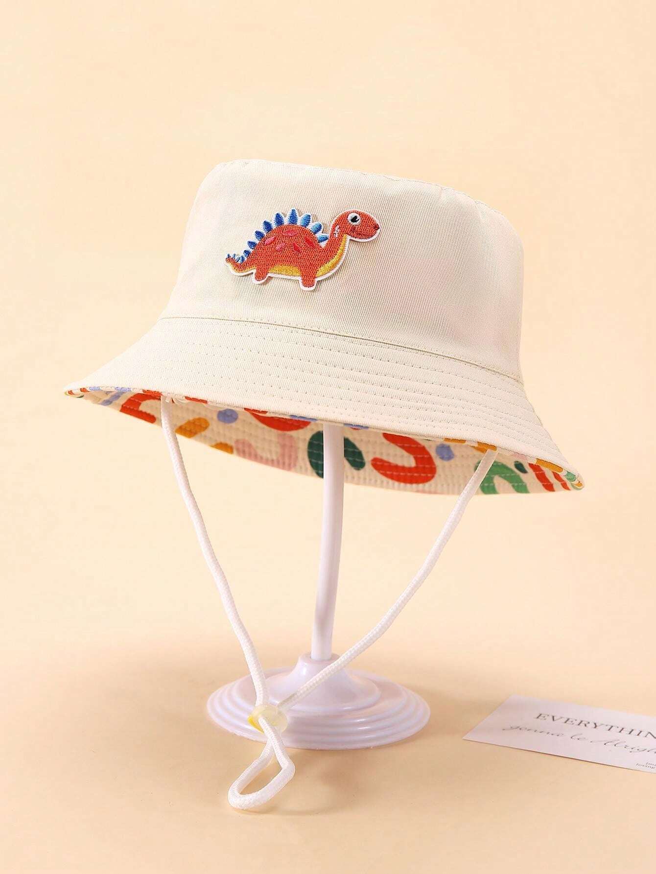Prenda beige sombrero cubo para bebe con dinosaurio bordado vista frontal