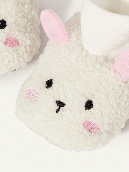 Prenda blanca pantuflas para bebe con orejas rosadas detalle lateral
