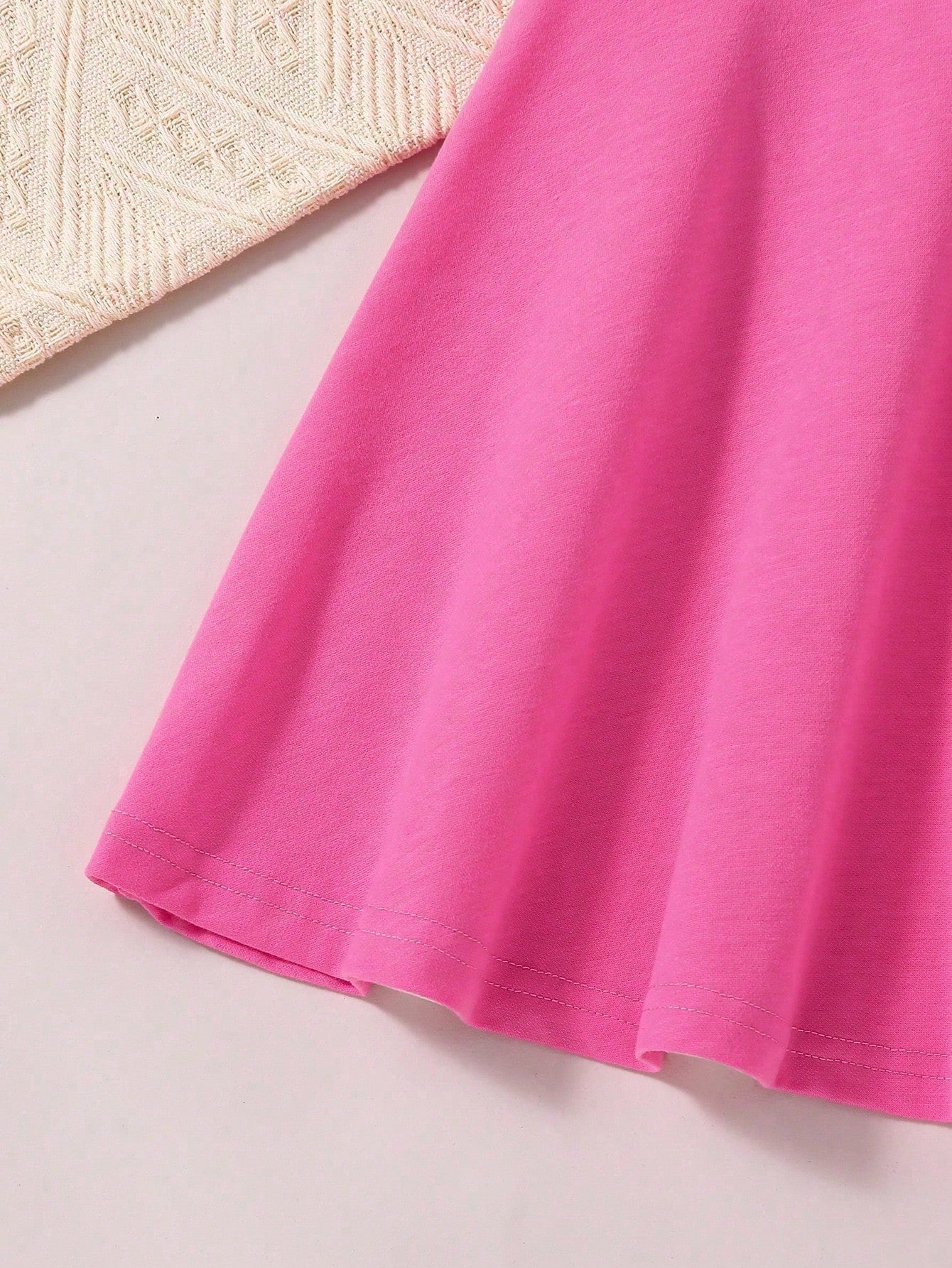 Prenda rosa fucsia vestido para bebe detalle del acabado inferior