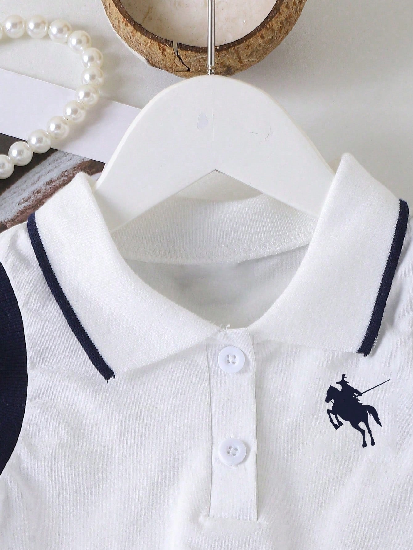 Prenda blanco y azul marino conjunto para bebe detalle de cuello polo y botones
