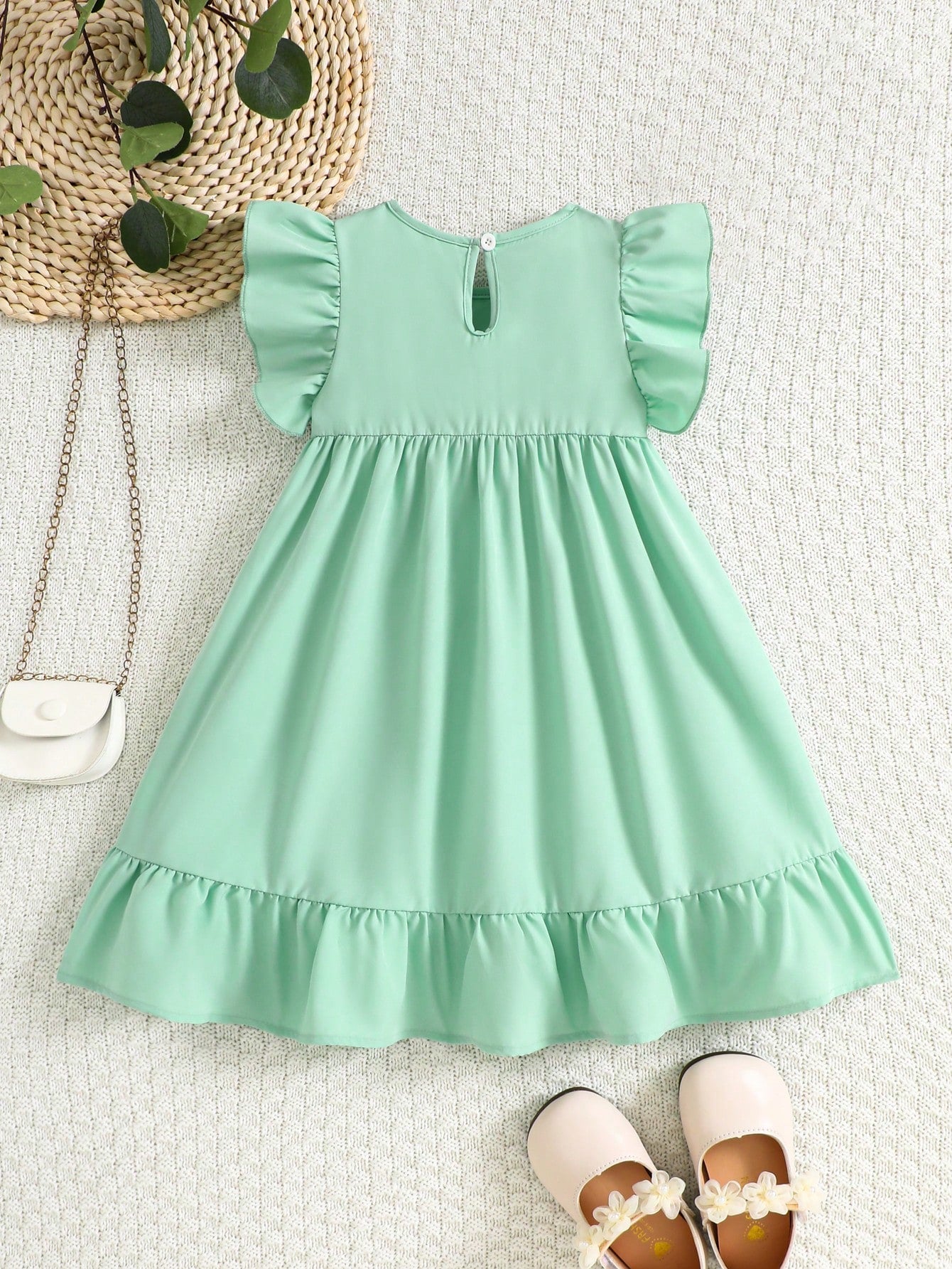 Prenda verde menta vestido para bebe con lazo y volantes vista posterior