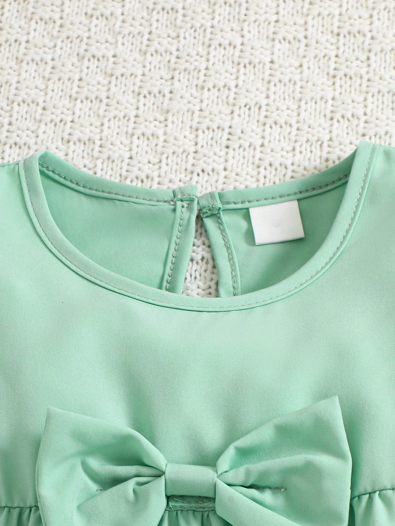 Prenda verde menta vestido para bebe detalle del cuello y cierre posterior