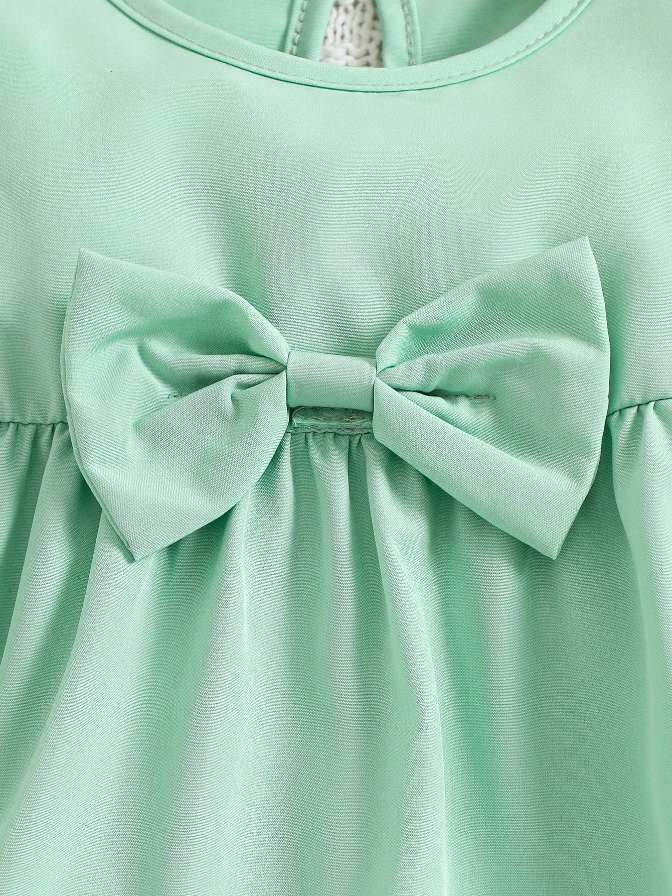 Prenda verde menta vestido para bebe detalle del lazo delantero