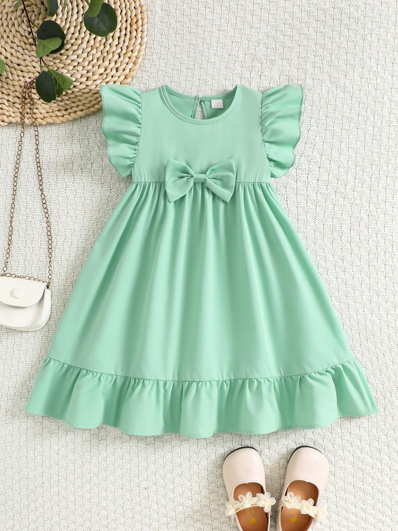 Prenda verde menta vestido para bebe con lazo y volantes vista frontal