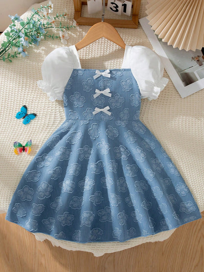 Prenda azul vestido para bebe con estampado floral y lazos frontales vista frontal