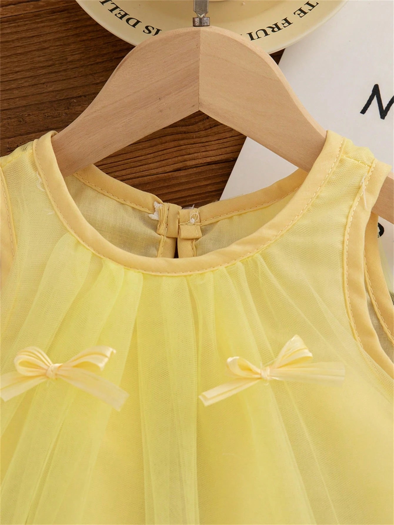 Prenda amarilla vestido de tul para bebe detalle del cuello y lazos aplicados
