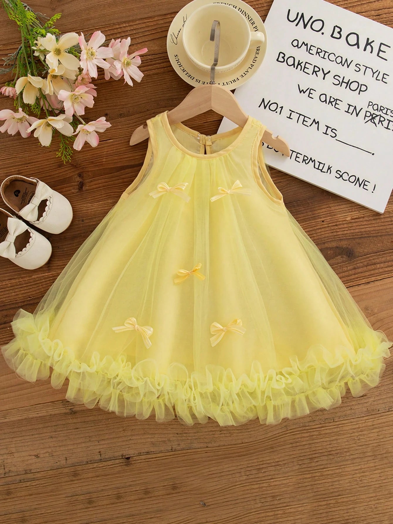 Prenda amarilla vestido de tul para bebe vista frontal con lazos decorativos y volantes