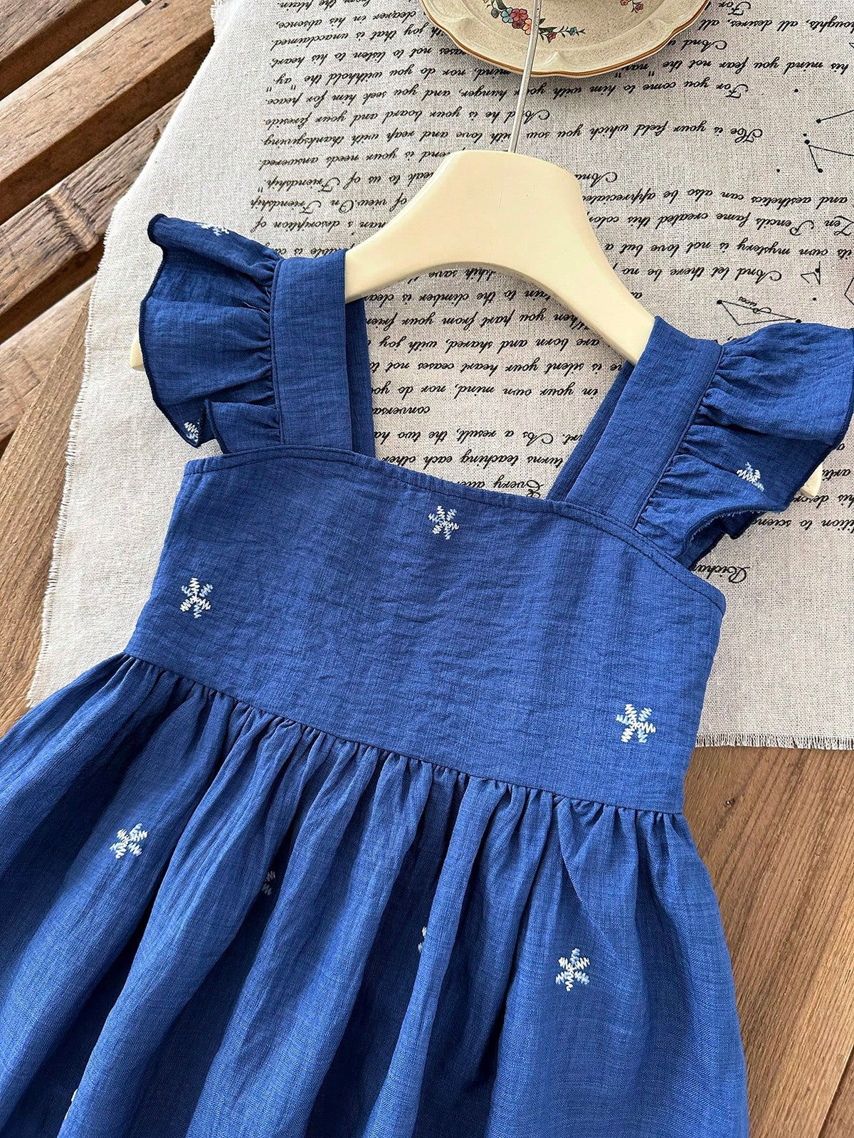 Prenda azul vestido para bebe detalle de escote cuadrado y volantes