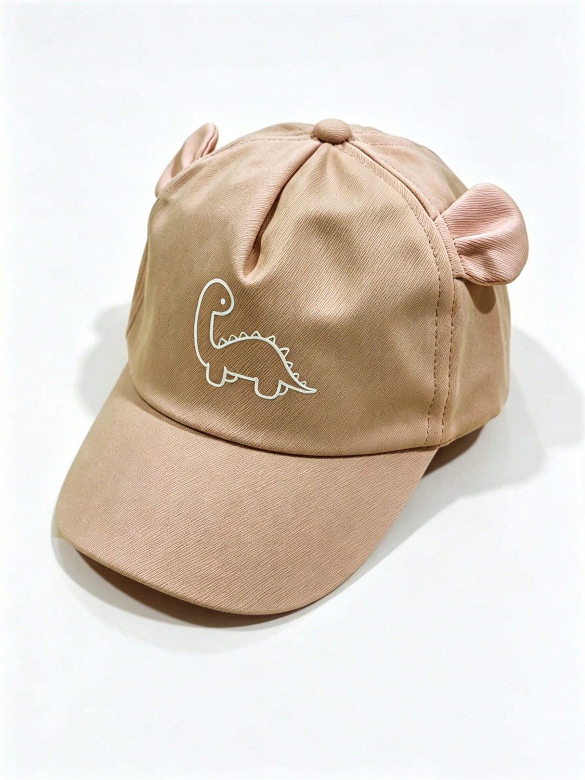 Prenda beige gorra para bebe con dinosaurio y orejitas vista frontal
