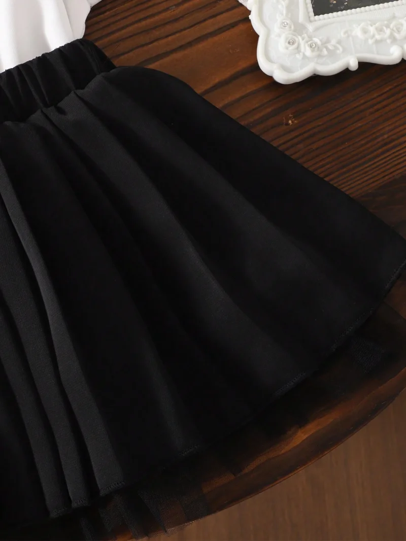 Conjunto blanco y negro con falda plisada y blusa bordada