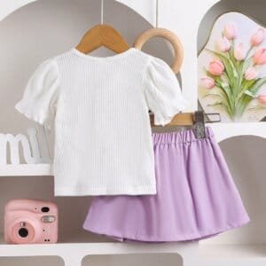 Conjunto morado con blusa bordada y falda plisada