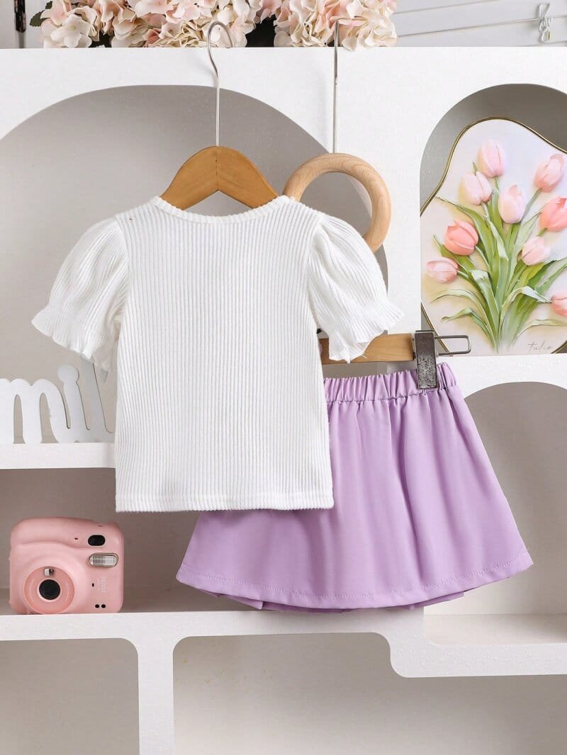 Conjunto morado con blusa bordada y falda plisada
