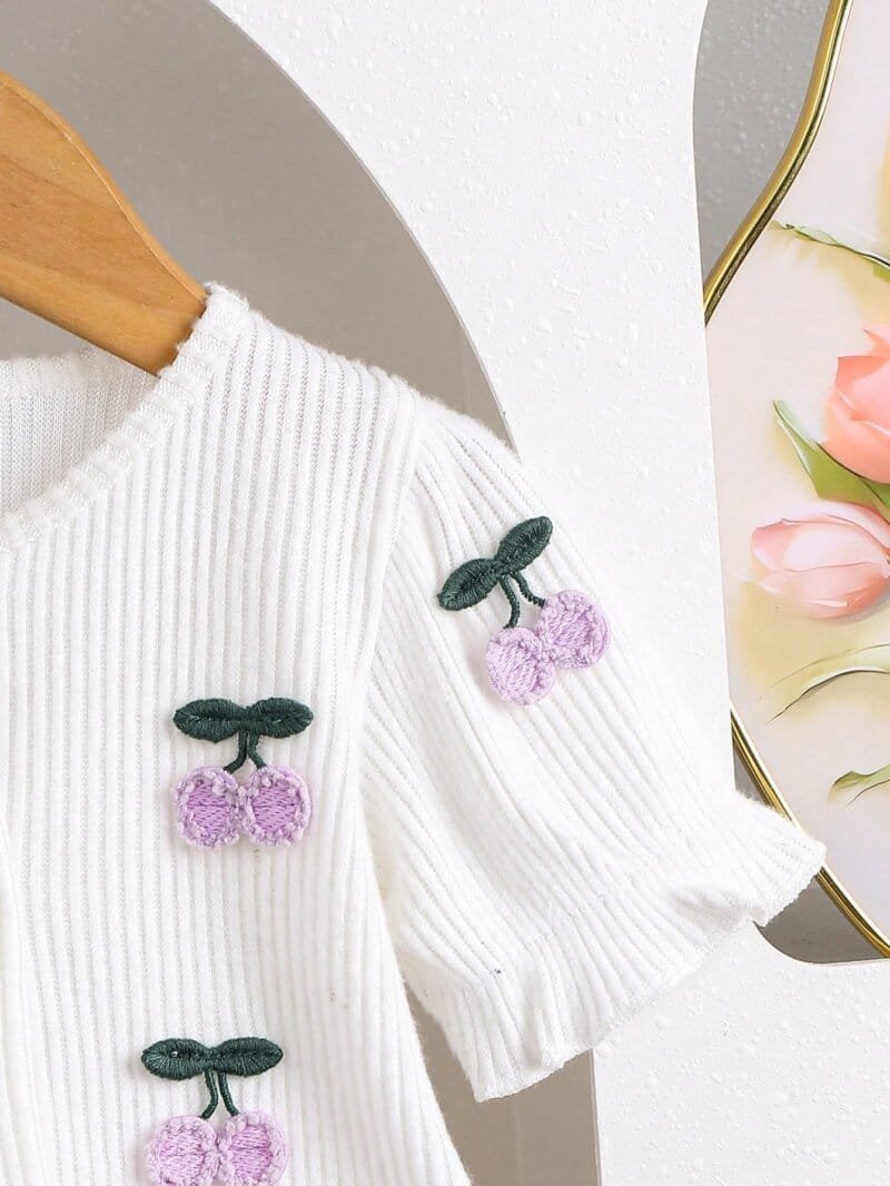 Conjunto morado con blusa bordada y falda plisada