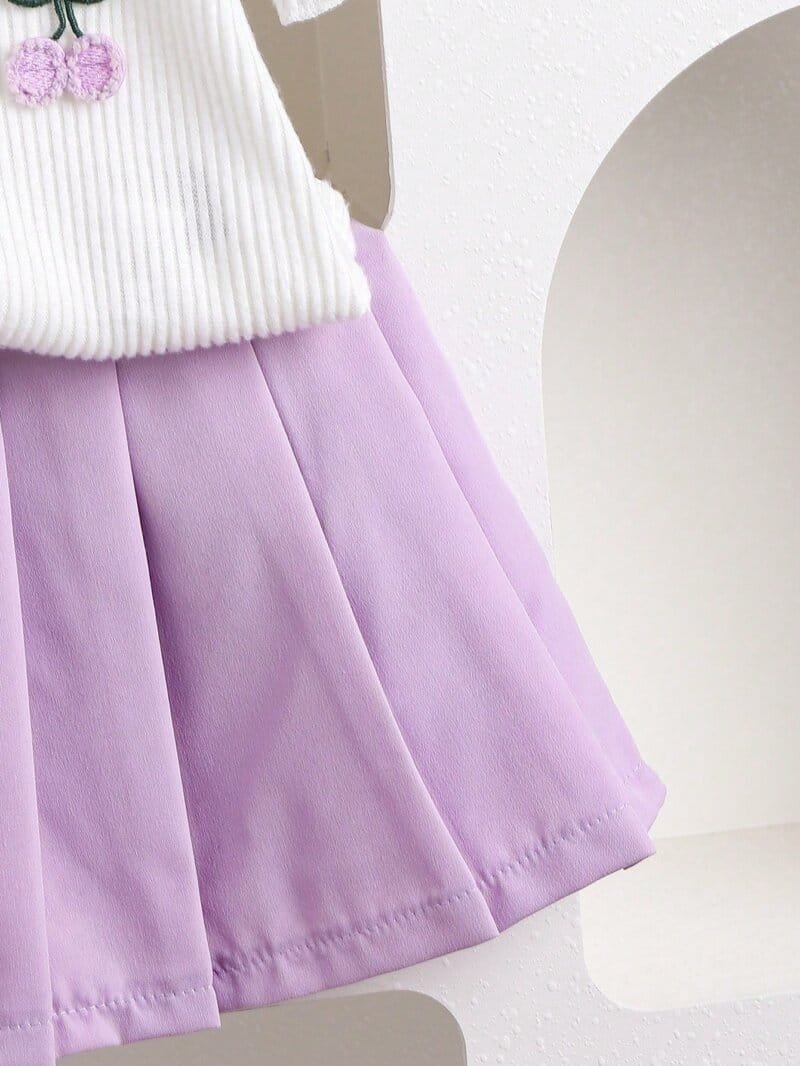 Conjunto morado con blusa bordada y falda plisada