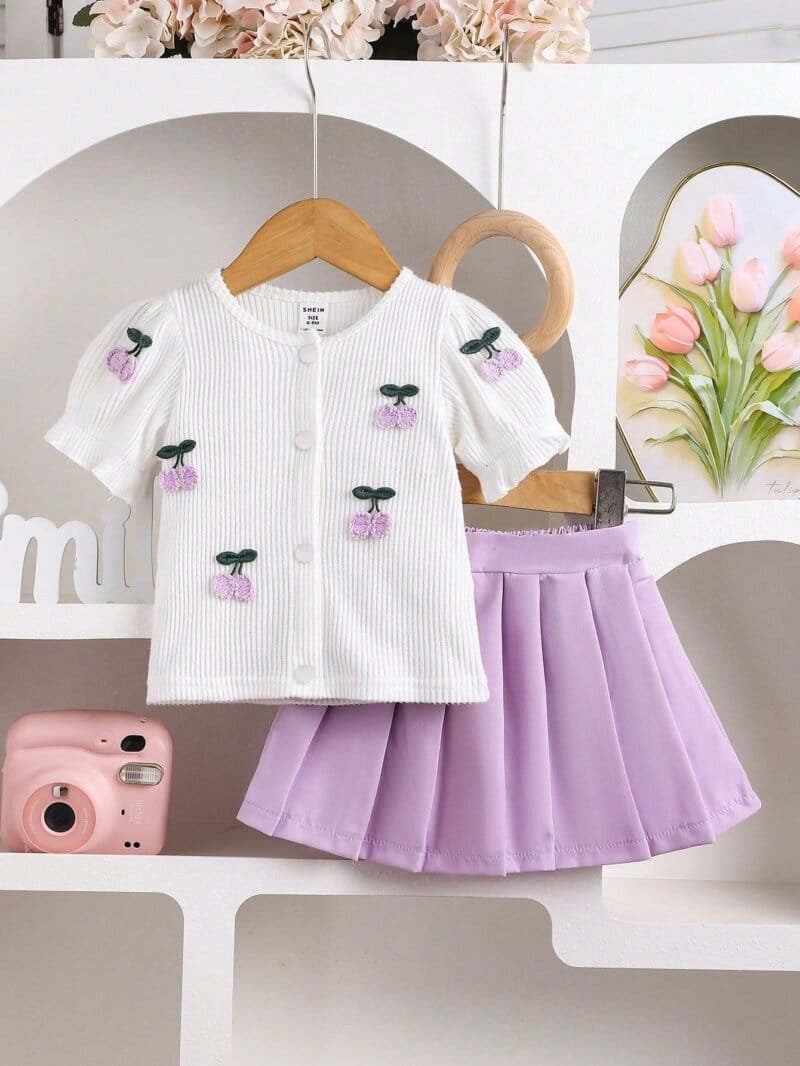 Conjunto morado con blusa bordada y falda plisada