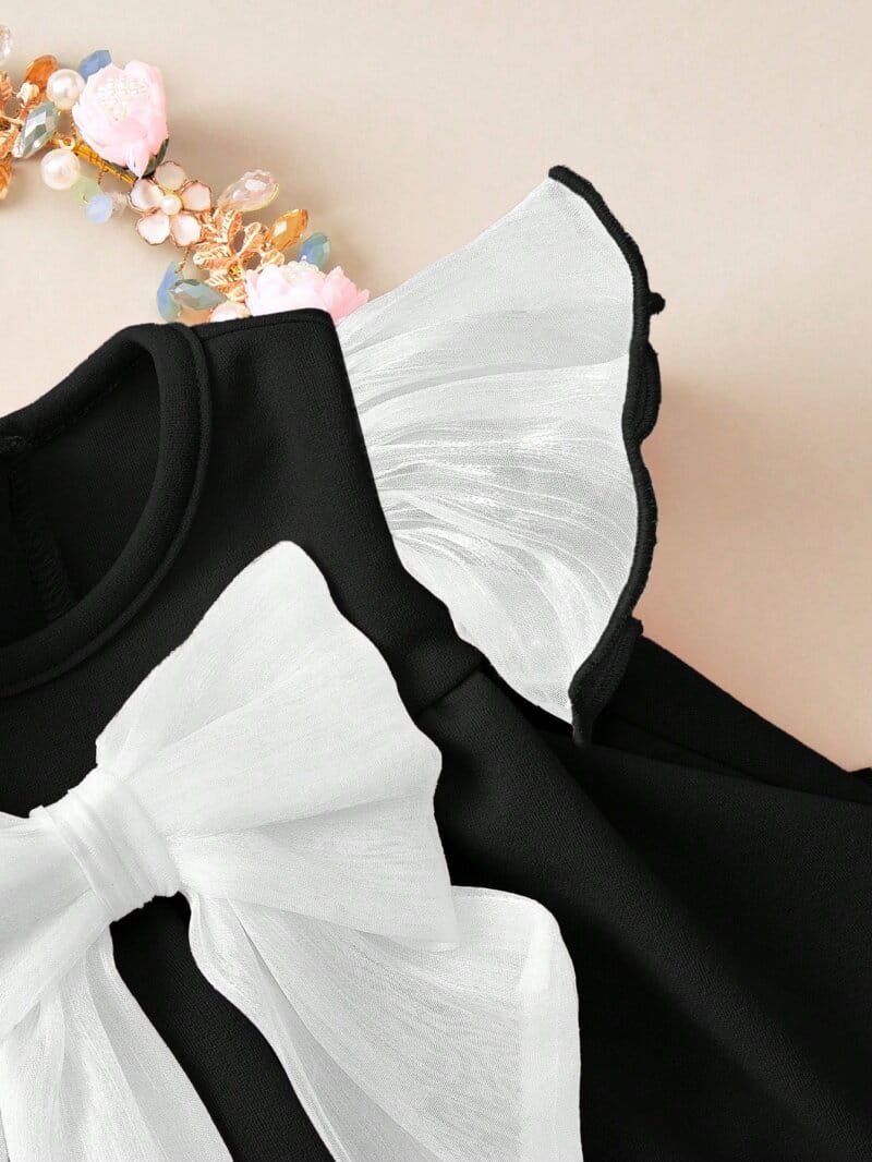 Vestido negro elegante con lazo blanco para bebé