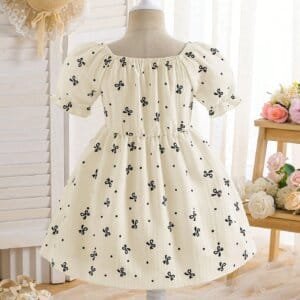 Vestido color albaricoque con lazos y bolso tejido