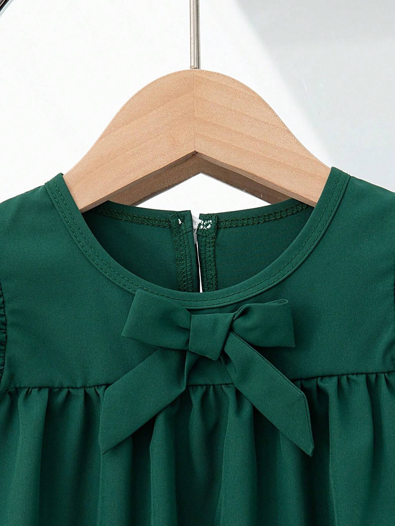 Vestido verde oscuro con moño delantero y mangas con volantes