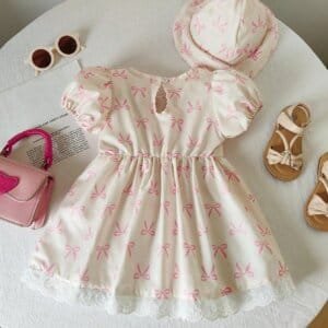 Vestido albaricoque con lazo rosa y sombrero a juego elegante