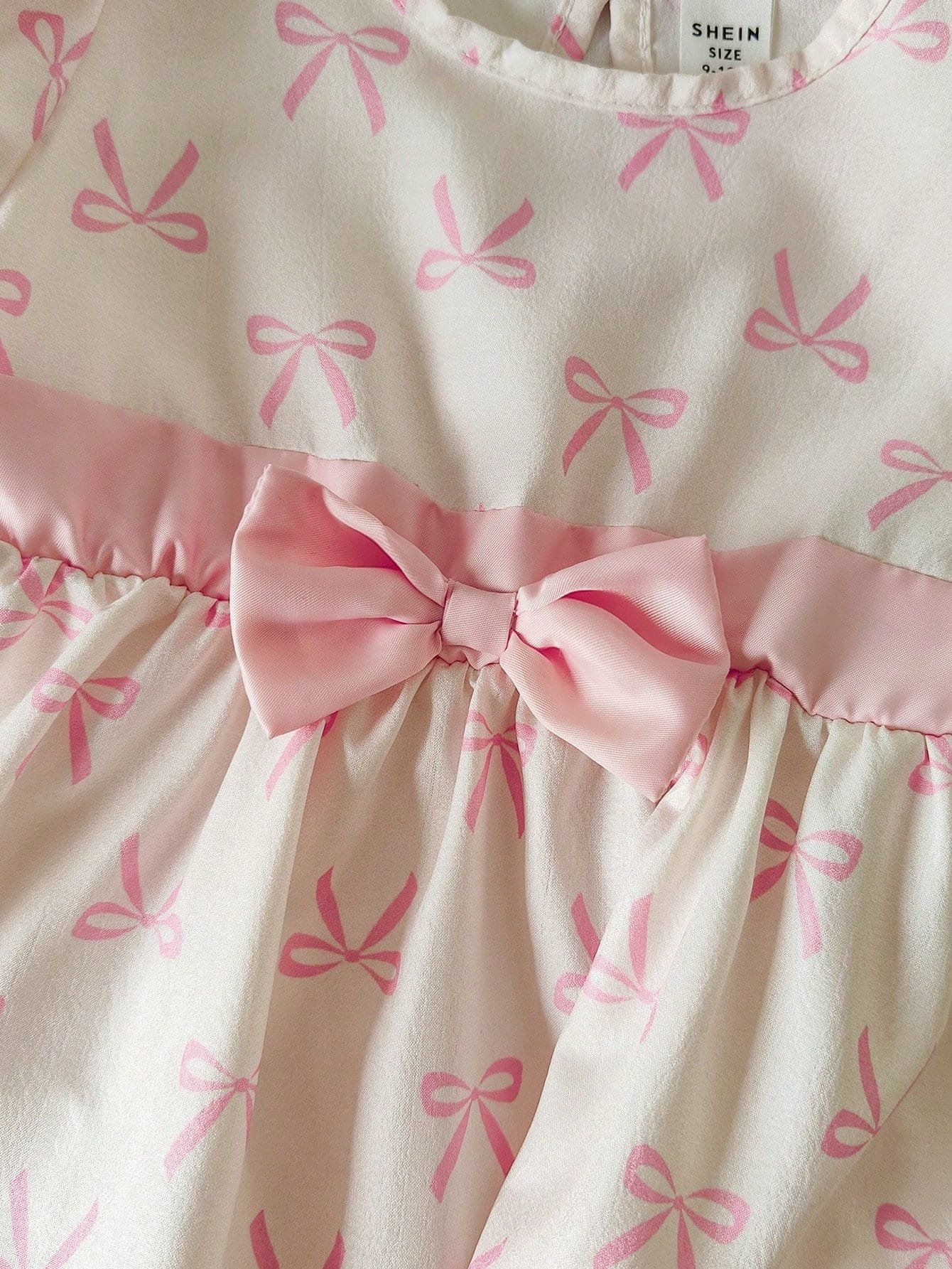 Vestido albaricoque con lazo rosa y sombrero a juego elegante