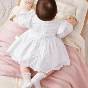 Vestido blanco bordado elegante con mangas largas y vuelo