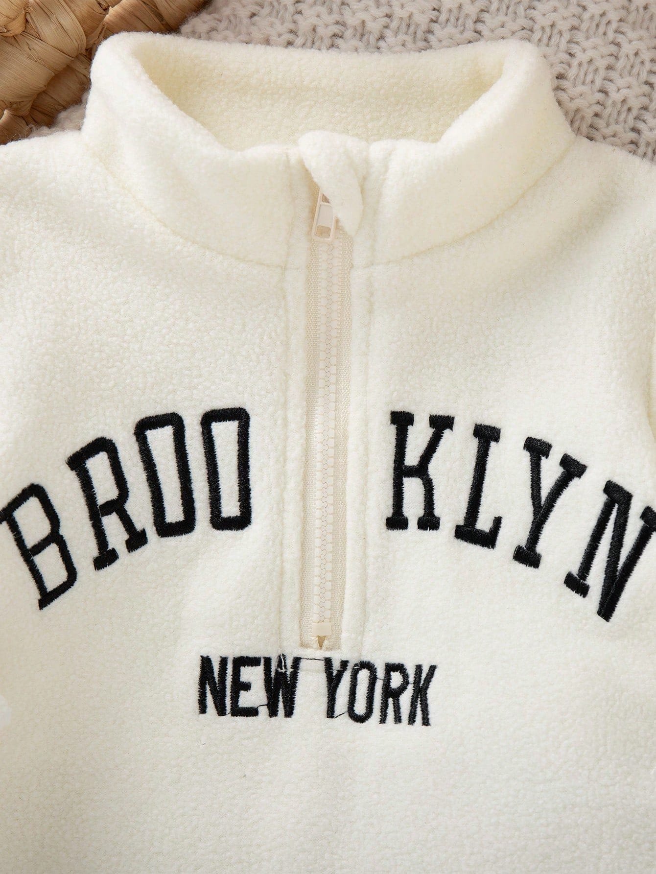 Conjunto bebé crema negro felpa con cierre frontal