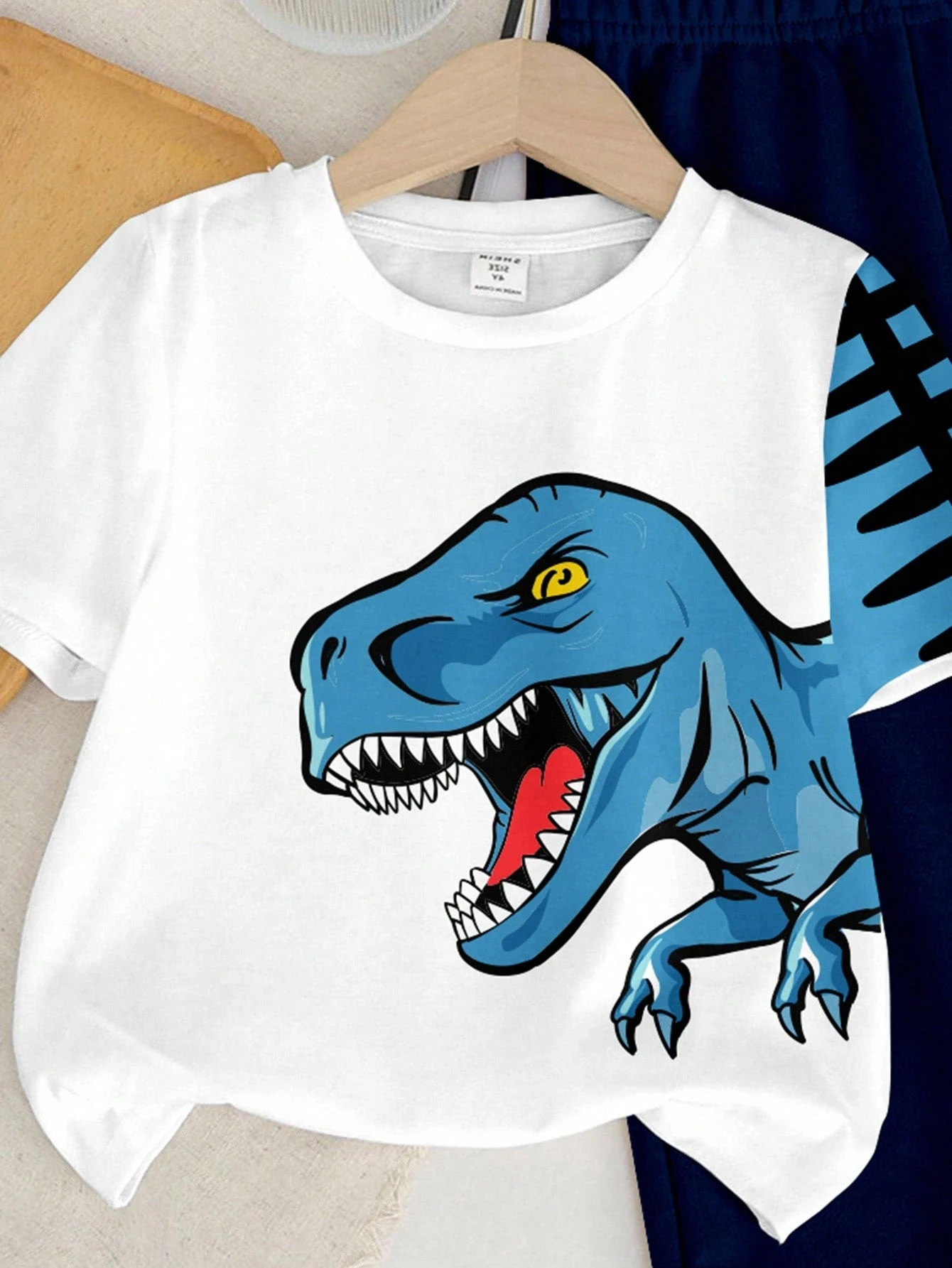 Conjunto blanco con dinosaurio y pantalón azul